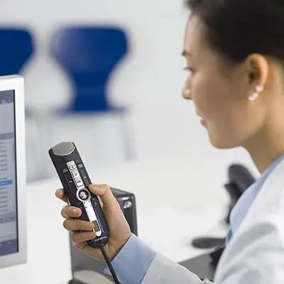 a woman is holding a remote control in front of a computer