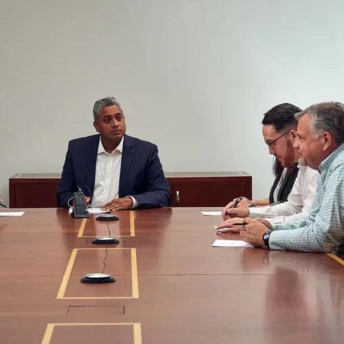 a group of men sitting around a conference table